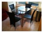 Glass extendable dining table and 4 black leather....